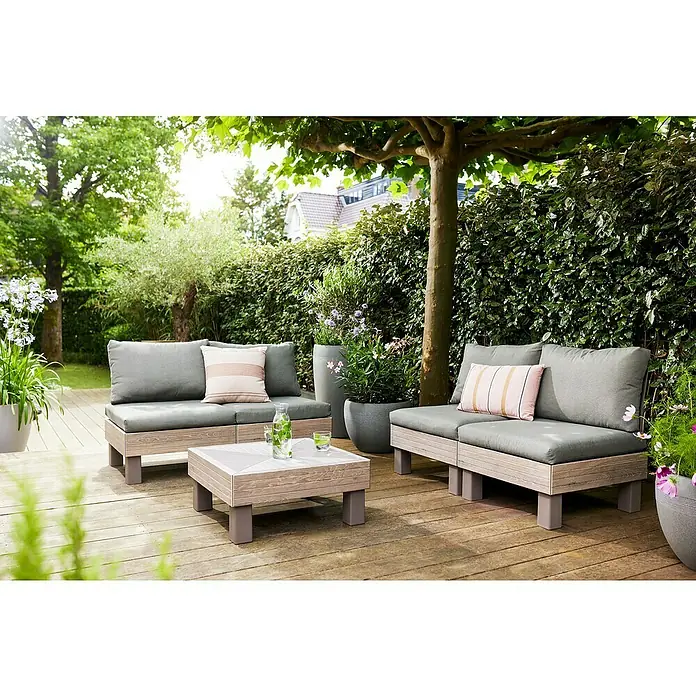 Keter Elements Respaldo de respaldo con cojín - L x An x Al: 60 x 17 x 57 cm, Madera/Verde - Conjunto de muebles de exterior con dos sofás y una mesa de centro en una terraza de madera, rodeado de exuberante vegetación.