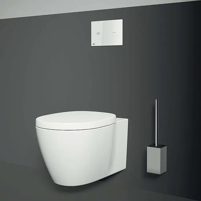 Ideal Standard Connect WC-Sitz - Duroplast, Weiß, Mit Absenkautomatik - Wandhängendes WC in Weiß mit Toilettenbürste und Betätigungsplatte vor grauer Wand für ein modernes Badezimmerdesign.
