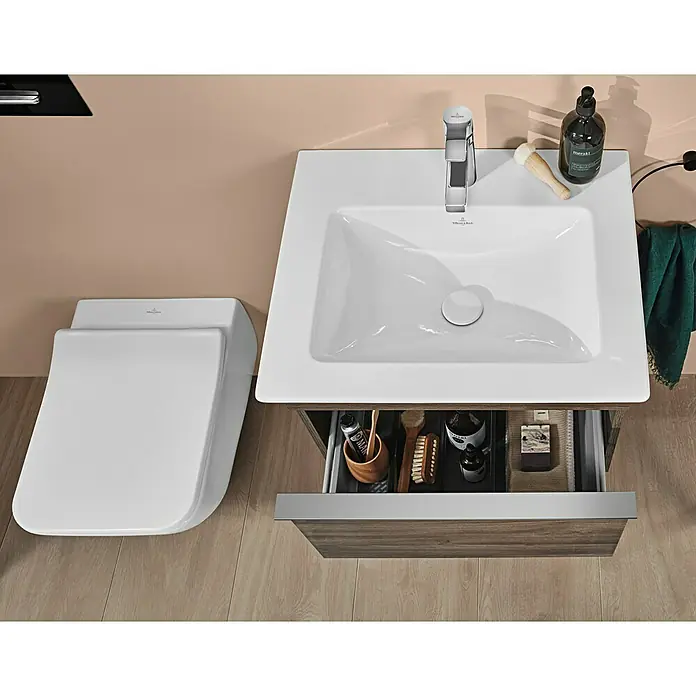 Villeroy & Boch Venticello WC-Sitz SlimSeat - Duroplast, Weiß, Mit Absenkautomatik - Eine moderne Badezimmeransicht von oben mit einer Villeroy & Boch Toilette und Waschbecken mit offenem Schubladenunterschrank.