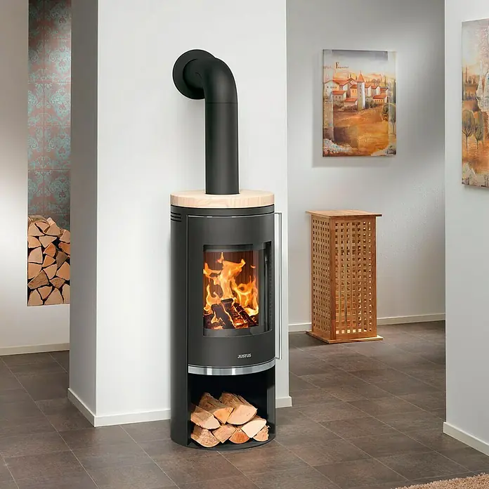 Justus Kaminofen Faro 2.0 - 6 kW, Raumheizvermögen: 115 m³, Verkleidung: Stahl/Sandstein, Schwarz - Moderner Justus Kaminofen mit Holzfach und loderndem Feuer, perfekt für gemütliche Stunden in Ihrem Zuhause.