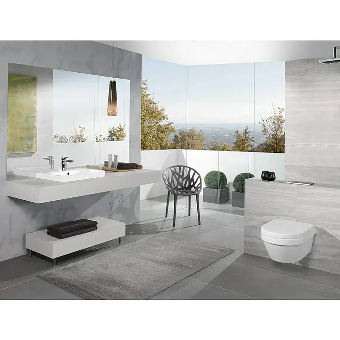 Villeroy & Boch Architectura WC-Sitz XL - Duroplast, Weiß, Mit Absenkautomatik - Ein modernes Badezimmer mit einem schwebenden Waschtisch und einer Toilette an der Wand, ergänzt durch eine stilvolle Möblierung und ein großes Fenster.
