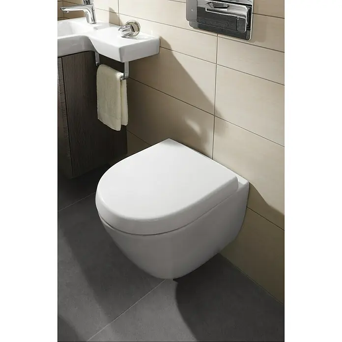 Villeroy & Boch Subway 2.0 WC-Sitz Compact - Duroplast, Weiß, Mit Absenkautomatik - Nahaufnahme einer modernen, wandhängenden Toilette in einem Badezimmer mit stilvollem Design und hochwertigen Armaturen.