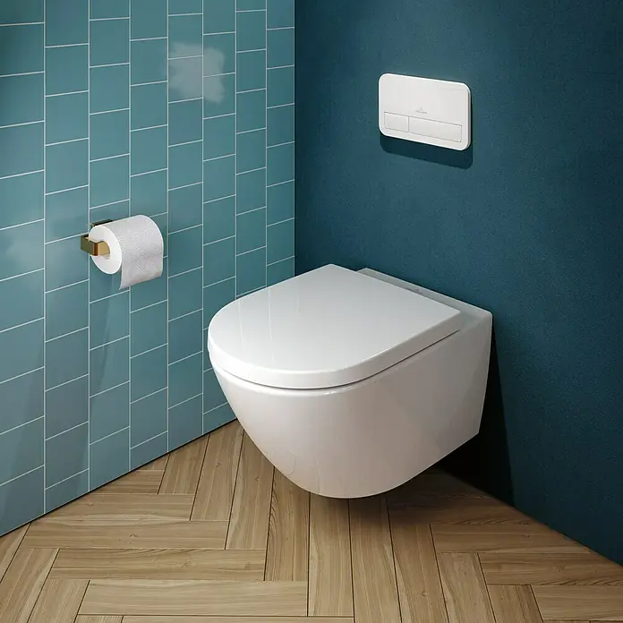 Villeroy & Boch Subway 3.0 WC-Sitz - Duroplast, Weiß Alpin, Mit Absenkautomatik, Mit antibakterieller Glasur - Weißes wandhängendes WC in modernem Bad mit blauen Wänden und Holzboden, mit Spülplatte und Toilettenpapierhalter.