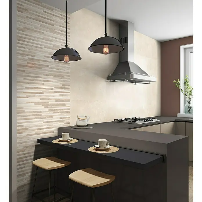 Revestimiento de pared Cantera - 33 x 55 cm, Arena, Mate - Cocina moderna con iluminación elegante y detalles de azulejos. Lámparas colgantes añaden un toque elegante sobre la isla con taburetes.