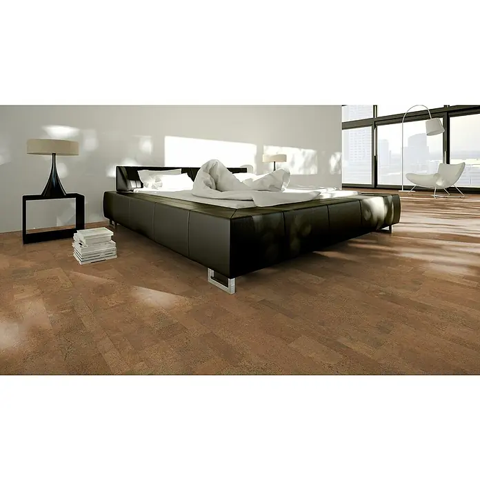 Granorte Korkboden Naturtrend - Element Rust, 910 x 300 x 9,5 mm - Warmer brauner Korkboden in einem modernen Schlafzimmer, der seine natürliche Textur und das abwechslungsreiche Dielenmuster zeigt.