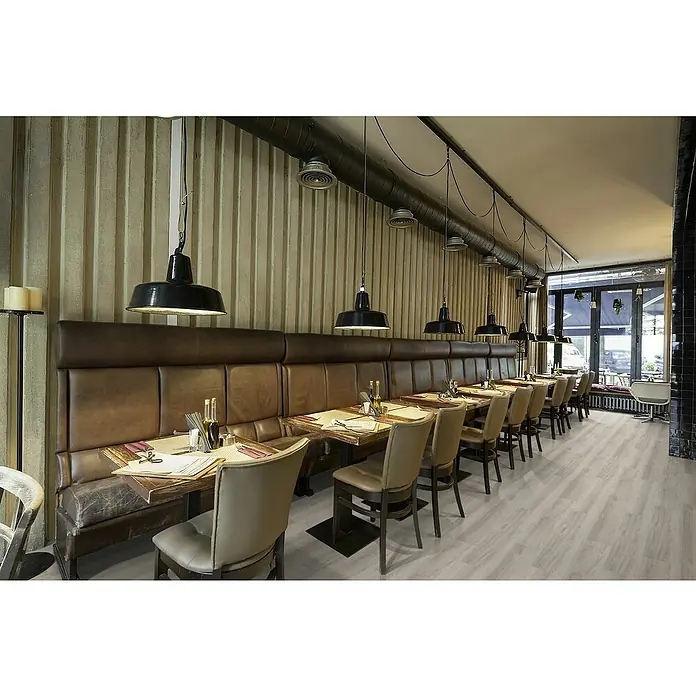 Granorte Designboden Kenkotrend - Ivory, 1.164 x 300 x 8,5 mm - Heller Holzoptikboden in einem Restaurant, der seine helle, natürliche Ästhetik und kommerzielle Eignung hervorhebt.