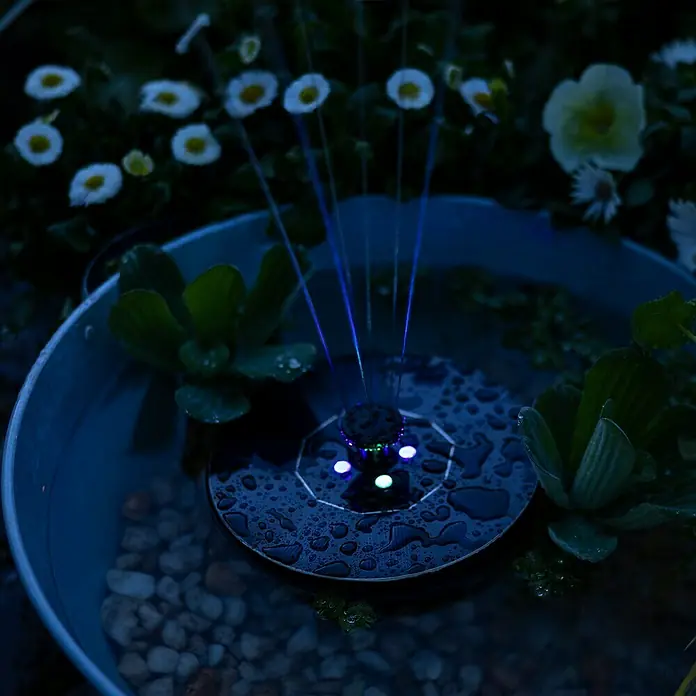 Fuente de jardín LED Lioni - Plástico, Negro - Fuente solar con luces LED de colores en un estanque de agua, rodeada de plantas para el jardín.