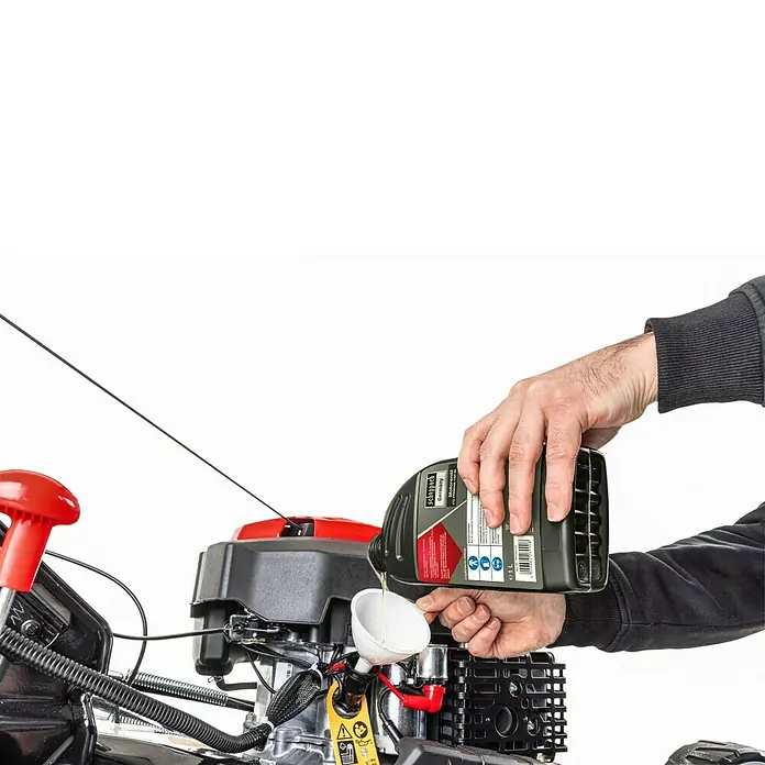 Scheppach Wartungs-Kit für Rasenmäher - 4-Takt-Benzin Geräte, 5 -tlg. - Person gießt Scheppach 4TZ PREMIUM 10W-40 Motoröl mit einem Trichter in eine Maschine.