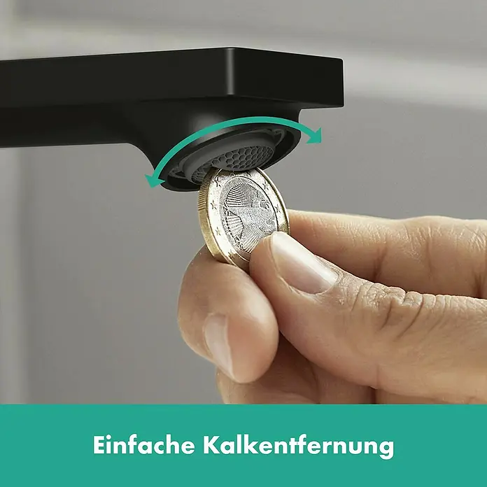 Hansgrohe Rebris E Waschtischarmatur 80 CoolStart Metall - Schwarz, Durchflussmenge: 5 l/min, Zugstange - Das Bild zeigt einen Wasserhahn, bei dem mit einer Münze der Kalk entfernt wird. Der Wasserhahn ist schwarz.