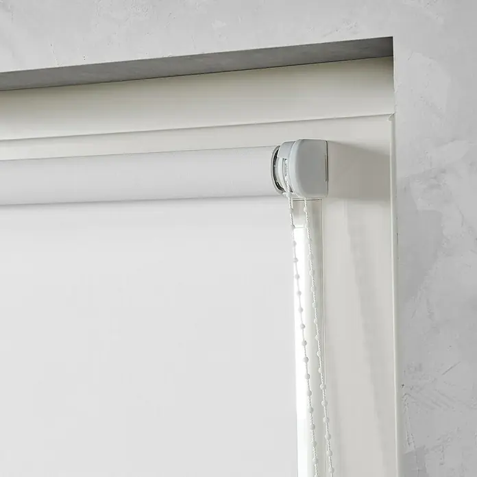 Expo Ambiente Klebeträger Rollo - Geeignet für: Rollos bis 143 cm Breite, 2 Stk. - Nahaufnahme einer weißen Rollade mit Kettenzug vor einem weißen Fensterrahmen. Das Produkt ist elegant und funktional.
