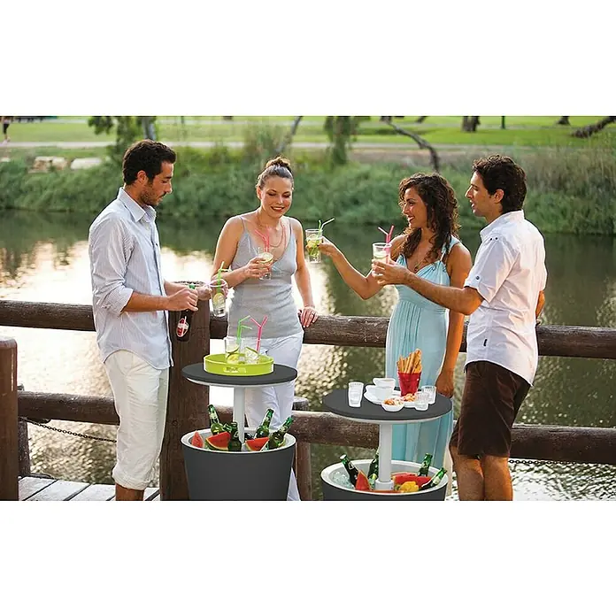 Keter Nevera Cool Bar - L x An x Al: 49,5 x 49,5 x 84,5 cm, Grafito/Blanco - Un grupo de amigos disfruta de bebidas en dos mesas de bar con refrigerador, llenas de bebidas y hielo.