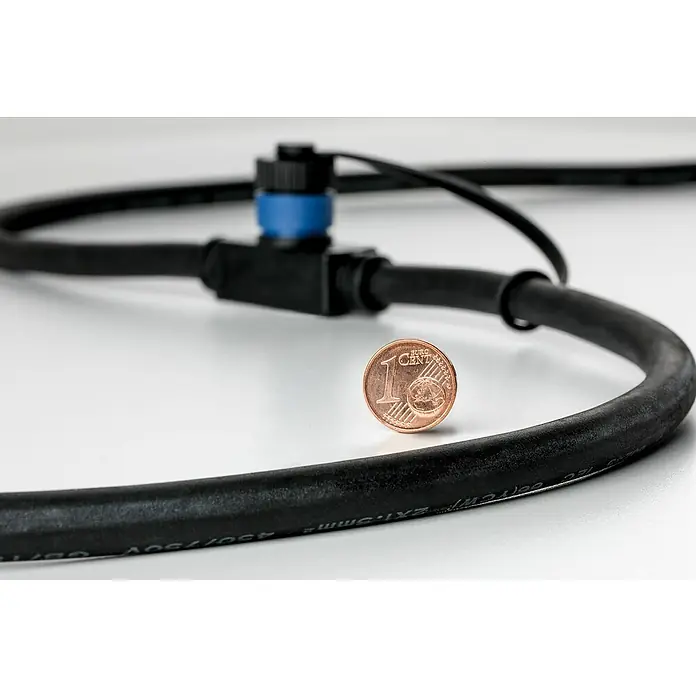 Paulmann Plug & Shine Verbindungskabel - 1 m, 2 Anschlüsse, IP68 - Nahaufnahme eines schwarzen Kabels mit blauem Stecker und einer 1-Cent-Münze zur Größenordnung auf einer weißen Oberfläche.