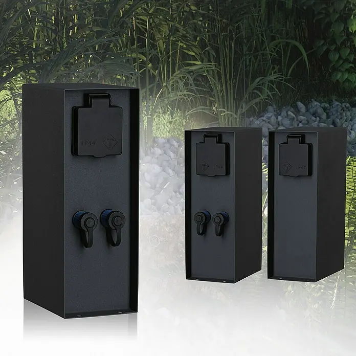 Paulmann Plug & Shine Steckdosensäule Rio - Anthrazit, Höhe: 23 cm, IP44, Ohne Dämmerungssensor - Drei schwarze Außensteckdosen mit IP44-Schutzklasse vor einem Gartenhintergrund. Praktische und sichere Stromversorgung im Freien.