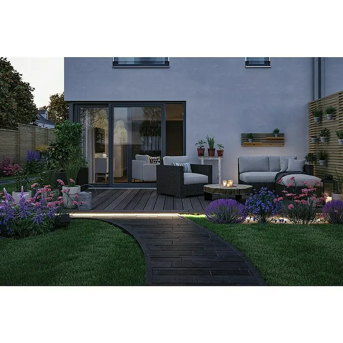 Paulmann LED-Band-Set Stripe Solar - 5 m, Warmweiß, 3,2 W, 300 lm, 5 V - Entspannender Außenbereich mit stilvollen Gartenmöbeln auf einer Terrasse und einem gepflasterten Weg, der durch blühende Blumenbeete führt.