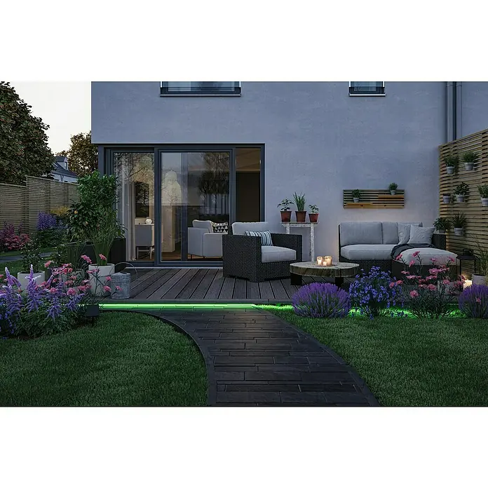 Paulmann LED-Band-Set Stripe Solar - 5 m, RGB, 3,2 W, 300 lm, 5 V - Ein einladender Außenbereich mit LED-Leuchten, einem Lounge-Set und üppigen Blumen, die ein entspannendes Ambiente schaffen.
