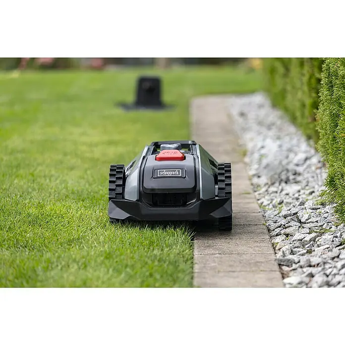 Scheppach Mähroboter BRMR300 - 300 m², Schnittbreite: 16 cm, Induktionsgestützte Navigation, Begrenzungskabel - Ein Scheppach Mähroboter steht auf einem gepflasterten Weg in einem Garten, bereit, den Rasen zu mähen. Die grüne Umgebung unterstreicht seine Funktion.