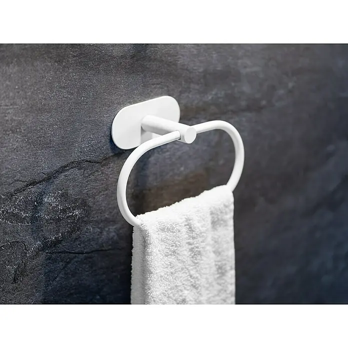 Wenko Orea Toallero de anilla - Blanco - Un toallero blanco con una toalla blanca colgando en una pared oscura. El toallero tiene un diseño elegante y funcional.