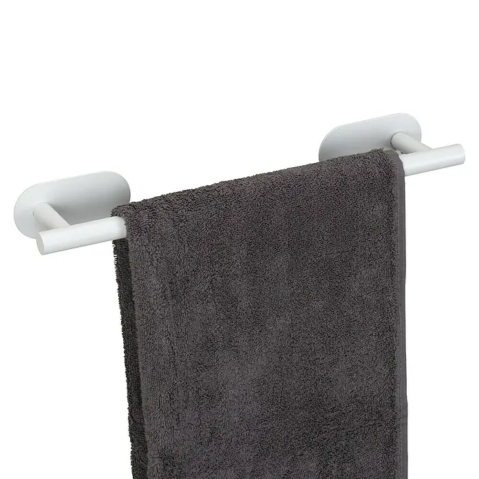 Wenko Orea Toallero de barra - Blanco - Toalla colgada en un toallero blanco. La toalla es gris y esponjosa. El toallero está montado en la pared, accesorio de baño.