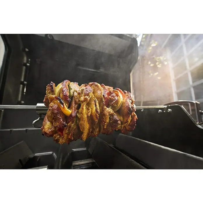 Weber Gasgrill Spirit E-310 - Grillfläche (B x T): 52 x 44 cm, 7 kW, Anzahl Brenner: 3 Stk. - Ein Drehspieß mit saftigem Fleisch und Gemüse wird auf einem Grill zubereitet, der köstlichen Rauch erzeugt.