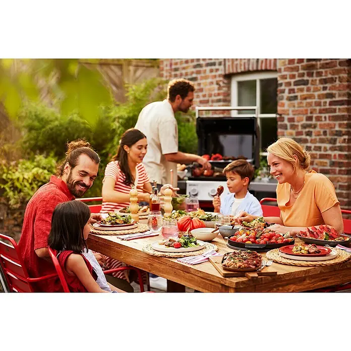 Weber Gasgrill Spirit EP-425 GBS - Grillfläche (B x T): 62 x 44 cm, 10,3 kW, Anzahl Brenner: 4 Stk. - Eine Familie genießt ein Outdoor-Grillen mit Gemüse und Fleisch, zubereitet auf einem modernen Grill, der im Hintergrund steht.