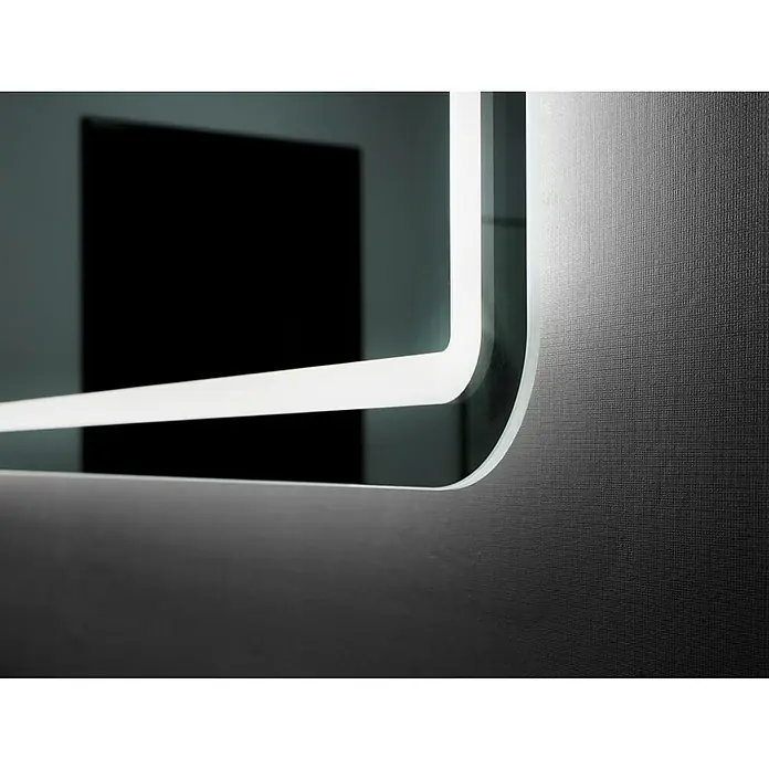 LedImex Espejo con luz Austria - 60 x 80 cm - Primer plano de un espejo iluminado con LED con esquinas redondeadas, montado en una pared texturizada. La luz proyecta reflejos en la superficie.