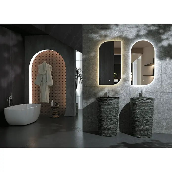 LedImex Espejo con luz Gales - 110 x 50 cm, Sensor, Función antivaho, Con sensor de movimiento - Un baño moderno con bañera exenta y dos lavabos de pedestal con aspecto de piedra bajo espejos iluminados.
