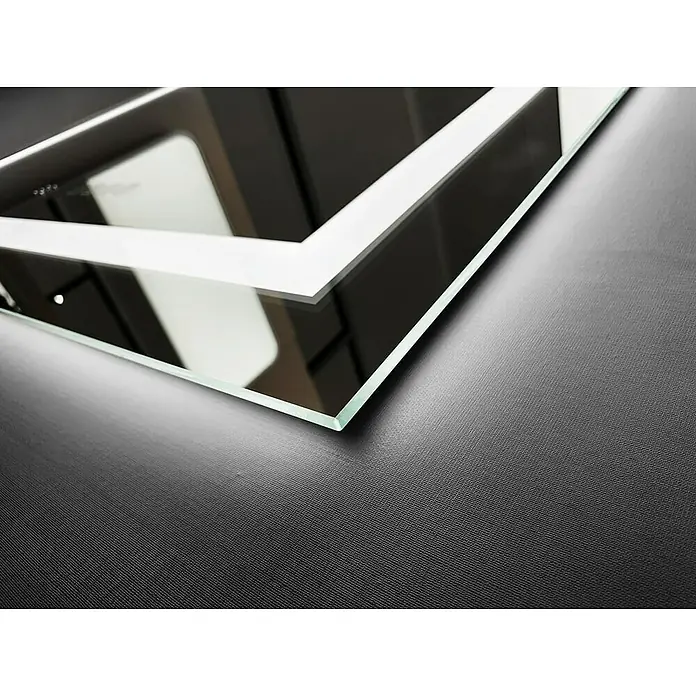 LedImex Espejo con luz Holanda - 100 x 80 cm, Sensor, Función antivaho - Primer plano de un espejo moderno iluminado con LED sobre una superficie texturizada. La luz resalta el diseño elegante.