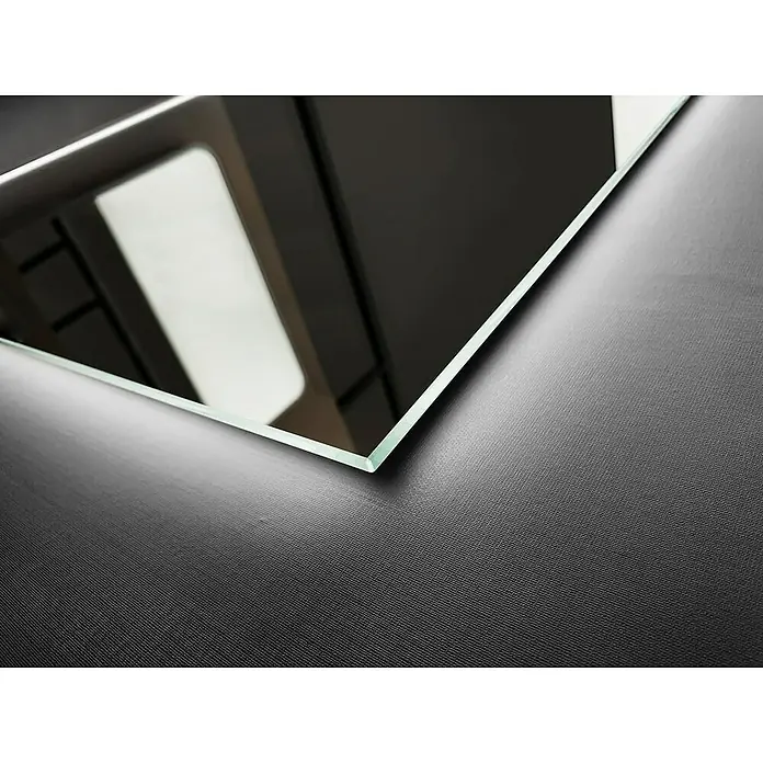 LedImex Espejo con luz Italia - 60 x 80 cm, Sensor, Función antivaho - Primer plano de un espejo de cristal sobre una superficie negra texturizada, resaltando la claridad y el reflejo del espejo.