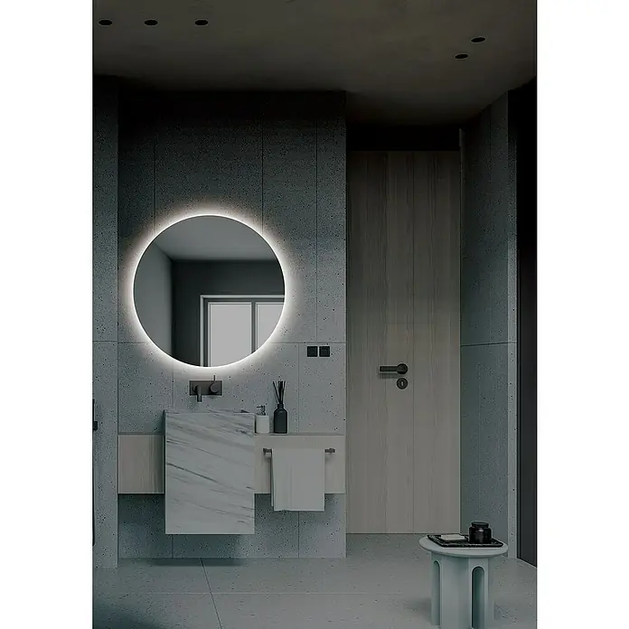 LedImex Espejo con luz Lisboa - Diámetro: 70 cm, Sensor, Función antivaho - Baño moderno con espejo LED redondo sobre un tocador de mármol, junto a una puerta de madera y un elegante taburete.