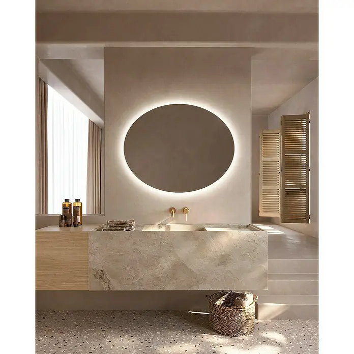 LedImex Espejo con luz Oval - 100 x 80 cm - Un baño con un espejo redondo iluminado sobre un elegante tocador y una cesta de ropa decorativa.