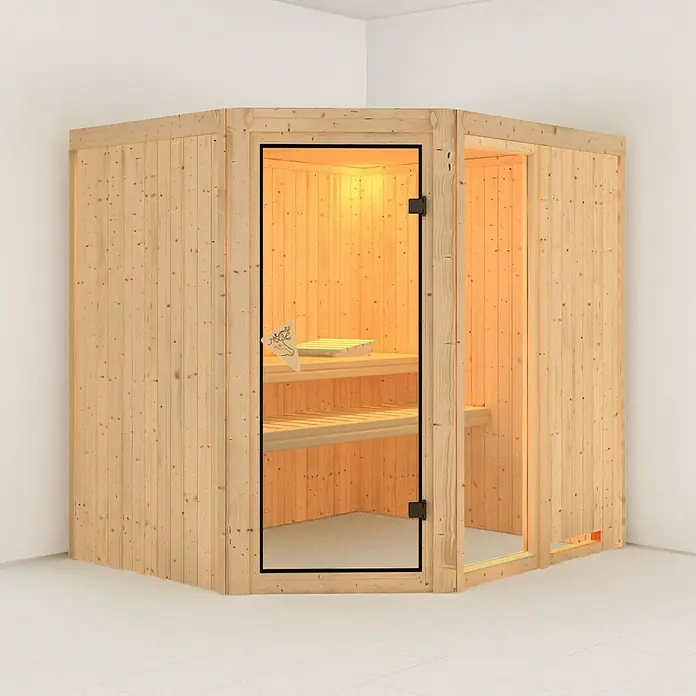 Karibu Elementsauna Fiona - Ohne Ofen, Ohne Dachkranz, L x B x H: 196 x 170 x 192 cm - Eine Ecksauna aus hellem Holz mit Glastür steht in einem Raum mit weißen Wänden und hellem Boden. Die Sauna hat Bänke zum Entspannen.