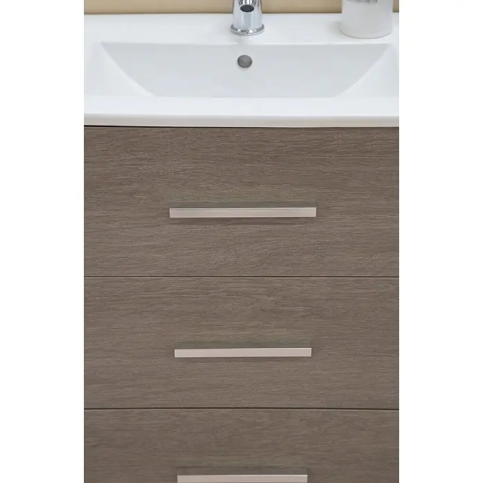 Rei Möbelgriff - Lochabstand: 64 mm, Aluminium, Chrom, Industrie, L x B x H: 120 x 12 x 18 mm - Moderner Badezimmer-Waschtisch mit weißem Waschbecken und drei holzfarbenen Schubladen mit silbernen Griffen.