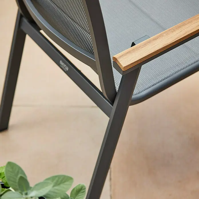 Siena Garden Stapelstuhl Tesoro High Back - 2 Stk., Ranotex®-Gewebe, Stapelbar, Anthrazit, B x T x H: 62,5 x 70,5 x 110 cm - Detailansicht eines grauen Gartenstuhls mit Armlehne aus Holz und einem Rahmen aus grauem Metall. Das Sitzmaterial ist grau.