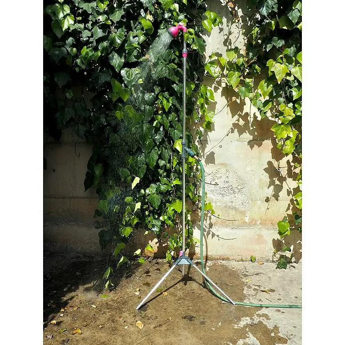 Ducha de jardín con trípode - Altura: 240 cm, Trípode, Aluminio, Fucsia - Imagen de una ducha exterior independiente con un cabezal de ducha rosa rociando agua con vegetación de fondo.
