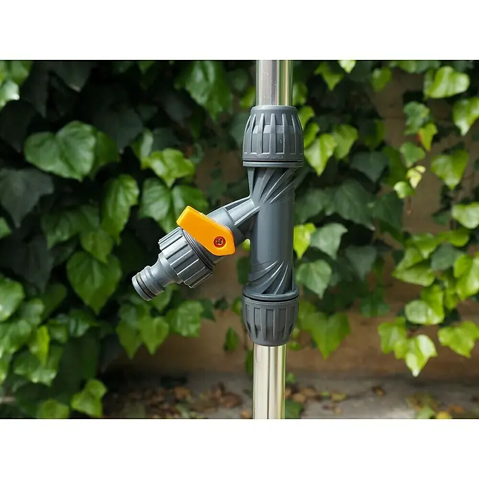 Ducha de jardín con trípode - Altura: 240 cm, Trípode, Aluminio, Naranja - Primer plano de un grifo de agua con mango amarillo conectado a un poste metálico, sobre un fondo verde.