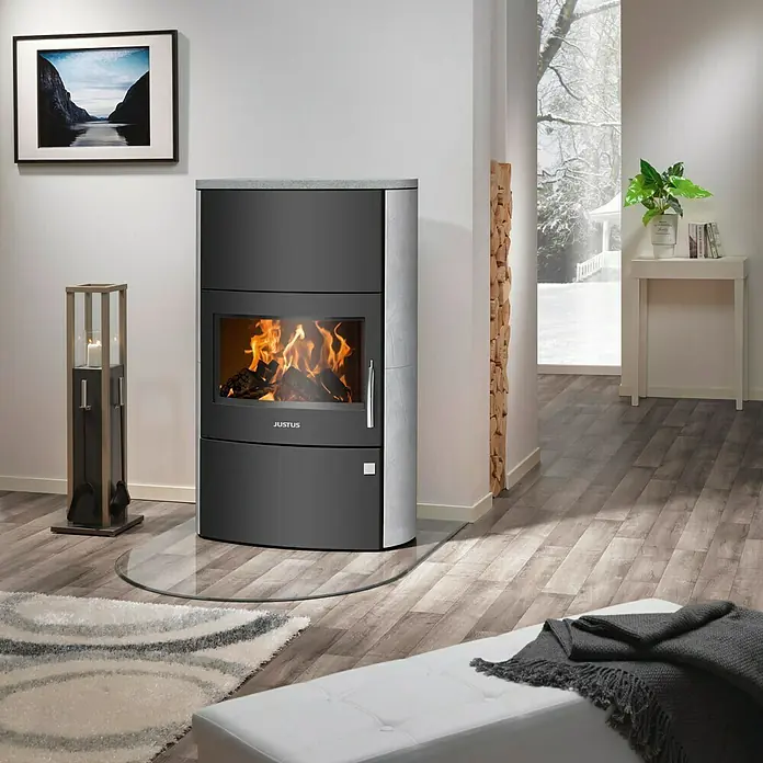 Justus Kaminofen Agero W+ - 7 kW, Raumheizvermögen: 144 m³, Material Verkleidung: Speckstein, Schwarz/Speckstein - Ein moderner Justus Kaminofen mit Glasbodenplatte und Holzscheitlagerung, der Wärme und Stil in jeden Wohnraum bringt.
