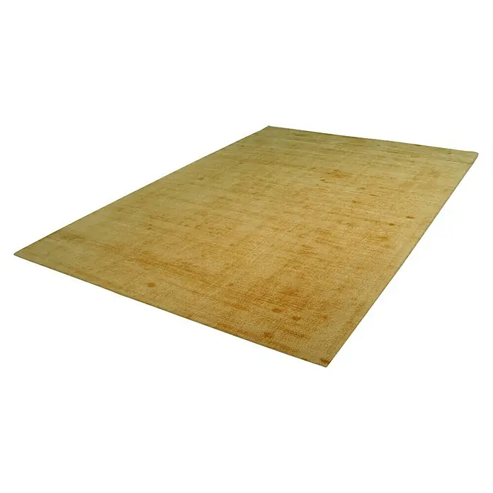 Kayoom Kurzflorteppich Luxury - Gelb, 170 x 120 cm, 100 % Viskose - Ein rechteckiger, goldfarbener Teppich liegt auf einem weißen Hintergrund. Der Teppich hat eine leichte Textur und einige dunklere Flecken.