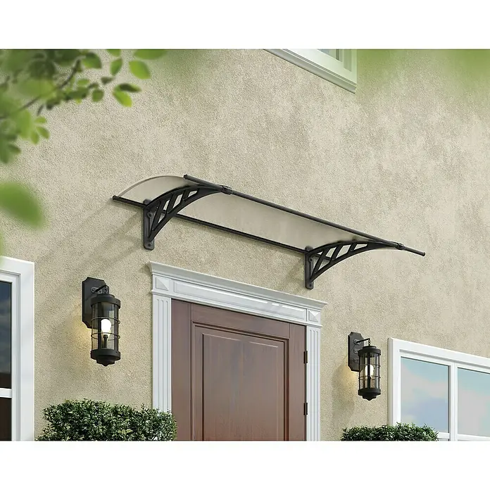 Palram – Canopia Pultvordach Apus - 119 x 76 x 25 cm, Anthrazitgrau - Eine stilvolle Türvordach-Konstruktion über einer Haustür, mit dekorativen Lampen an der Wand, die das Gebäude elegant aufwerten.
