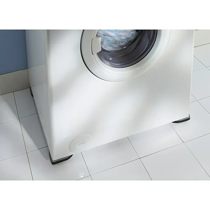Vibrationsdämpfungsmatte - 4 -tlg., Grau - Detailaufnahme einer weißen Waschmaschine, die auf grauen Antivibrationspads auf hellen Fliesen steht. Fokus liegt auf den Pads.