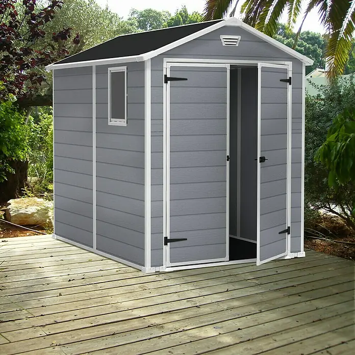 Keter Caseta de jardín Manor 6x8 - Medidas ext. (An x Pr): 185,8 x 236,8 cm, Gris Claro/Blanco, Plástico, Área: 3,9 m² - Caseta de jardín gris con puertas abiertas sobre una terraza de madera. La caseta de jardín ofrece almacenamiento y protección contra la intemperie.