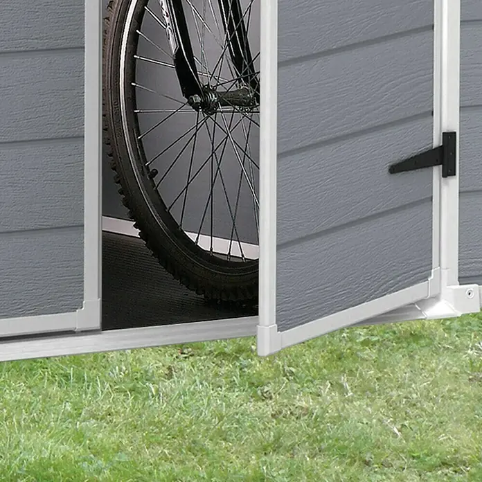 Keter Caseta de jardín Manor 6x8 - Medidas ext. (An x Pr): 185,8 x 236,8 cm, Gris Claro/Blanco, Plástico, Área: 3,9 m² - Vista detallada de un cobertizo de jardín gris con puerta abierta, dentro del cual hay una bicicleta aparcada sobre césped verde.