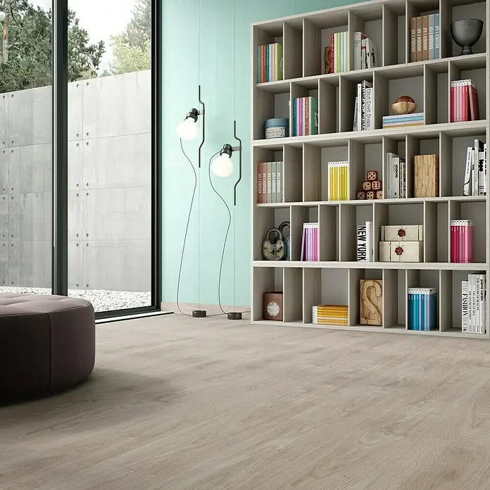 LOGOCLIC Laminado Roble Nature - 1.200 x 196 x 8 mm, Roble Nature, AC4 - Un interior luminoso y acogedor con una estantería y asientos, resaltado por el cálido suelo de madera.