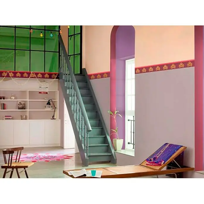 Bruguer Colores del Mundo Pintura para paredes - Egipto ocre suave, Mate, 4 l - Diseño de interiores luminoso con una escalera, estanterías, una ventana y muebles que crean un ambiente acogedor y atractivo.