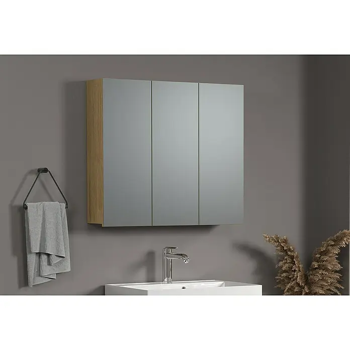 Trendteam Niklas Spiegelschrank - B x H: 90 x 80 cm, Evoke Eiche - Ein dreitüriger Badezimmerspiegelschrank mit Holzdetails hängt über einem modernen Waschbecken und bietet praktischen Stauraum im Bad.