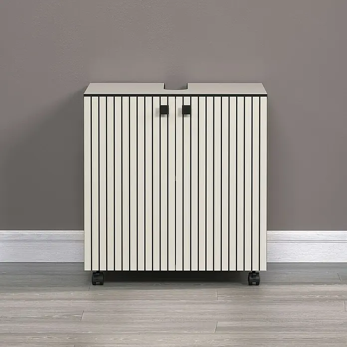 Trendteam Niklas Waschtischunterschrank - B x T x H: 60 x 42 x 64 cm, Kashmir, Strukturiert - Ein beiger Schrank mit vertikalen Streifen und schwarzen Griffen steht auf einem Holzboden vor einer grauen Wand.