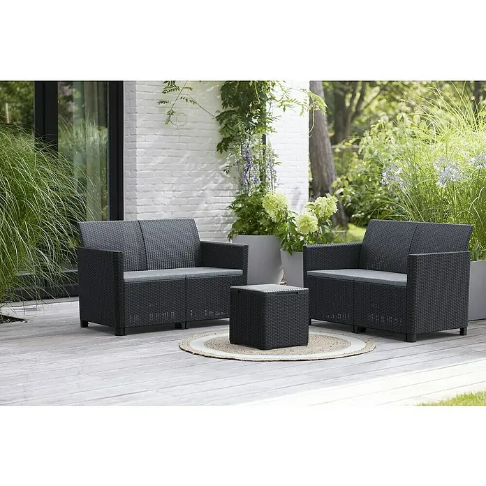 Keter Conjunto de muebles Marie - 3 pzs., Polipropileno, Negro - Un elegante conjunto de muebles de exterior con un sofá de ratán negro, sillón y mesa auxiliar, situado en un patio de madera.