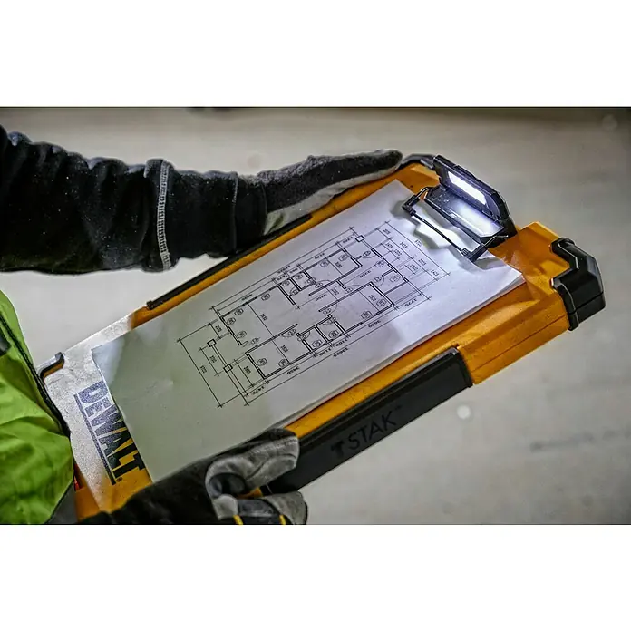 DeWalt T-STAK Klemmbrett - L x B x H: 28,5 x 41,3 x 32 cm, Kunststoff, LED-Licht - Bauarbeiter mit leuchtendem DEWALT-Klemmbrett, das einen Bauplan hält und die Arbeit im Dunkeln erleichtert.