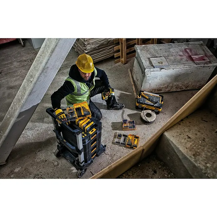 DeWalt T-STAK Transportroller - L x B x H: 59 x 55 x 104,3 cm, Kunststoff, Traglast: 100 kg - Ein Bauarbeiter mit gelbem Helm und die DeWalt Werkzeugsets und Bohrmaschine in gelb-schwarz im Innenraum.