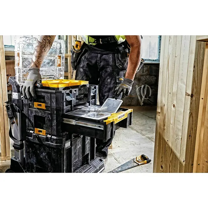 DeWalt T-STAK Werkzeugkasten III - L x B x H: 44 x 18 x 31 cm, Kunststoff, Traglast: 7,5 kg - Arbeiter öffnet Schublade einer schwarz-gelben DEWALT TSTAK Werkzeugbox, zeigt transparente Fächer mit Befestigungsmitteln.