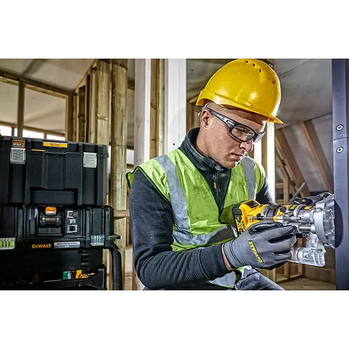 DeWalt Caja para herramientas DWST83346-1 - L x An x Al: 333 x 440 x 302 mm, Plástico, Con cerradura - Trabajador con equipo de seguridad usando una fresadora DeWalt inalámbrica amarilla y negra en una obra.